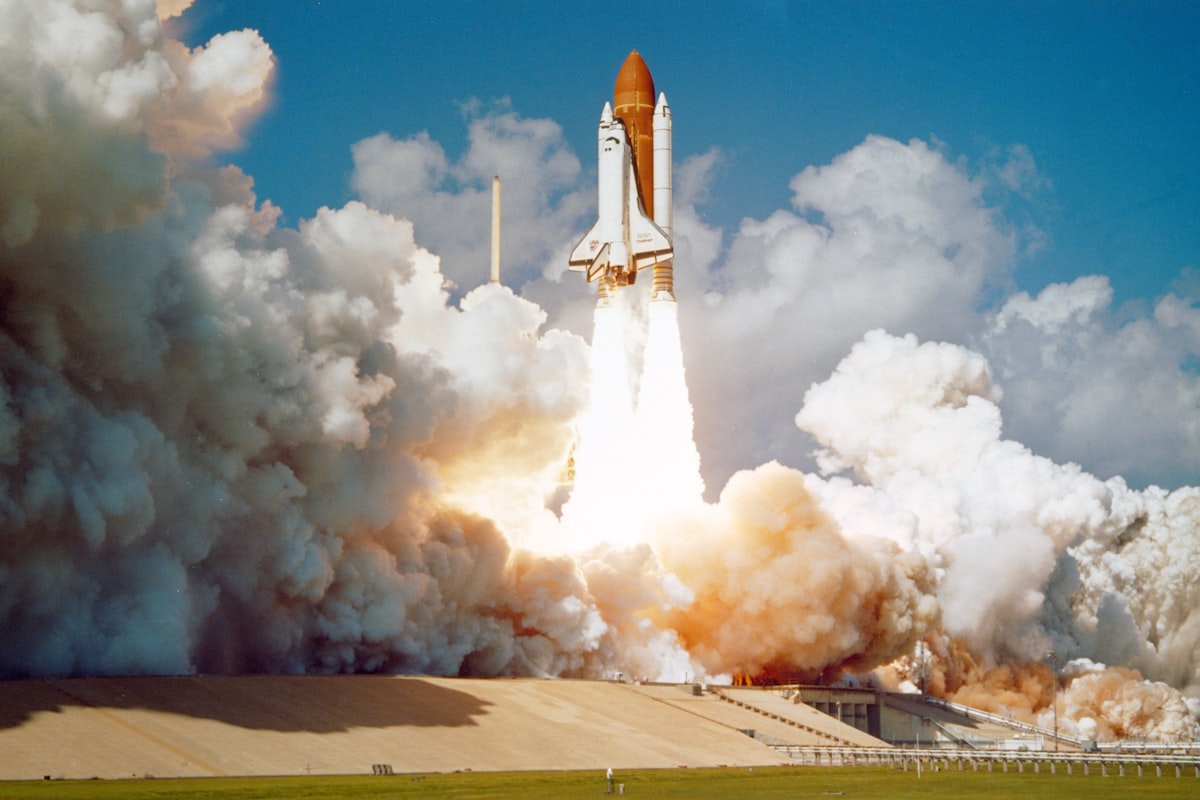 Space shuttle climbing into the sky on a column of exhaust
